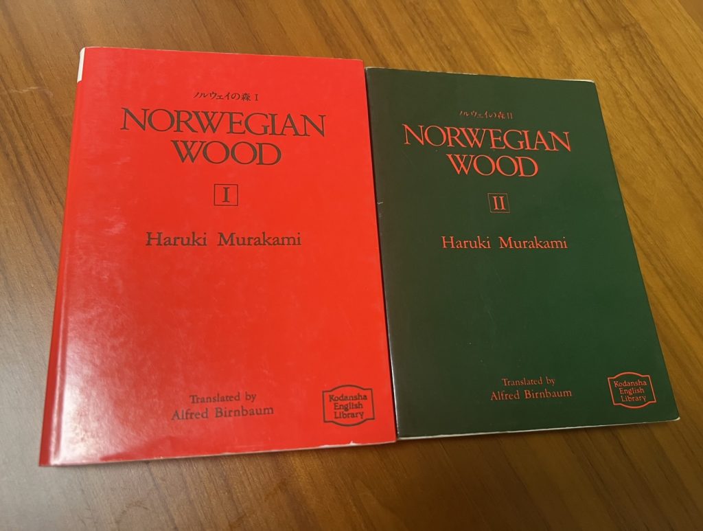 The two-volume Alfred Birnbaum translation of Haruki Murakami's Norwegian Wood with red and green covers on a table.