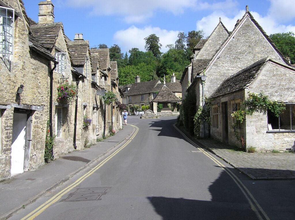 The main street in the village of Castle Combe in England, a small road with picturesque stone houses on both sides.